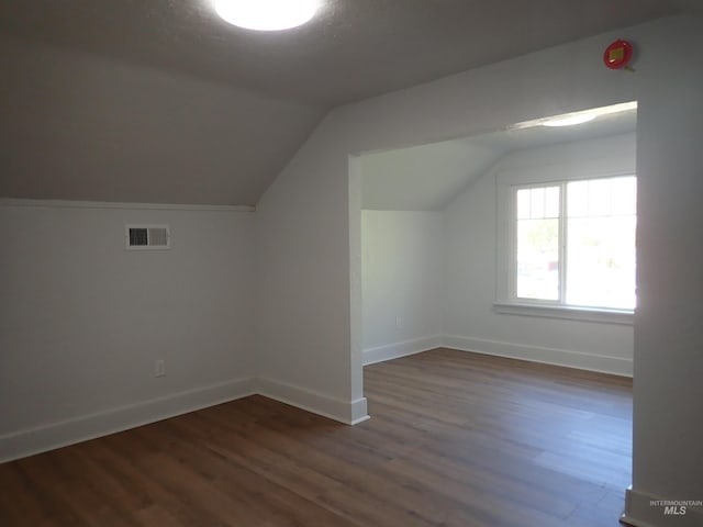 additional living space featuring lofted ceiling and dark hardwood / wood-style floors