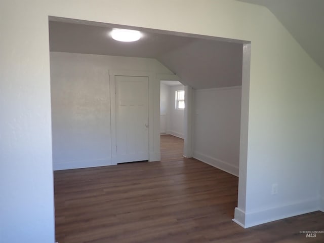 bonus room with dark hardwood / wood-style floors and vaulted ceiling