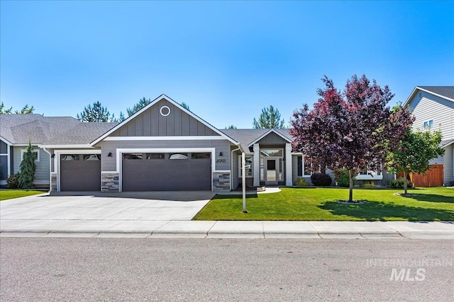 4991 N Sun Shimmer Ave, Meridian, ID 83646 - view of front facade with a garage, a front lawn, stone siding, driveway, and board and batten siding