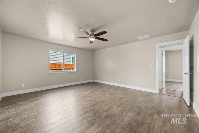 4991 N Sun Shimmer Ave, Meridian, ID 83646 - unfurnished room with ceiling fan, wood-type flooring, baseboards, and a textured ceiling