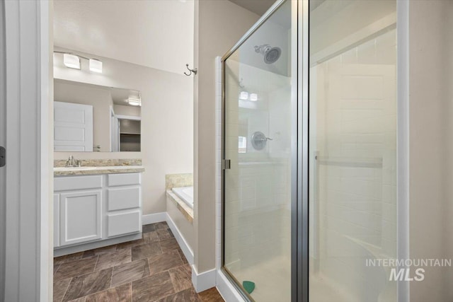 4991 N Sun Shimmer Ave, Meridian, ID 83646 - bathroom featuring a shower stall, vanity, a garden tub, stone finish floors, and baseboards