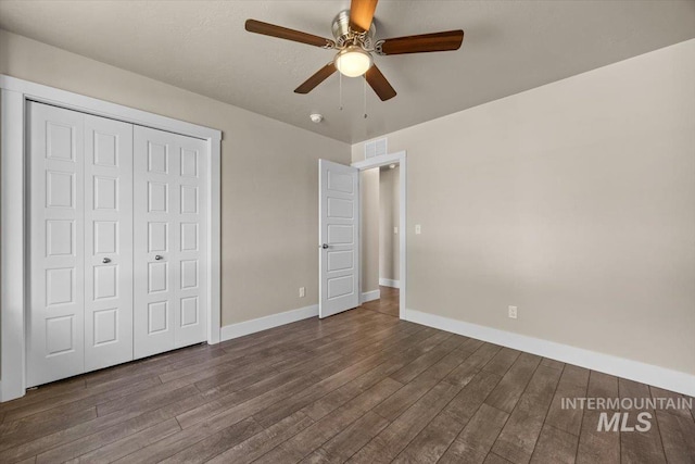 4991 N Sun Shimmer Ave, Meridian, ID 83646 - unfurnished bedroom with dark wood-style flooring, baseboards, a closet, and a ceiling fan