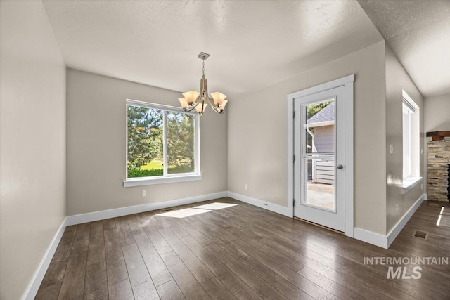 4991 N Sun Shimmer Ave, Meridian, ID 83646 - unfurnished dining area with a chandelier, dark wood-type flooring, and baseboards