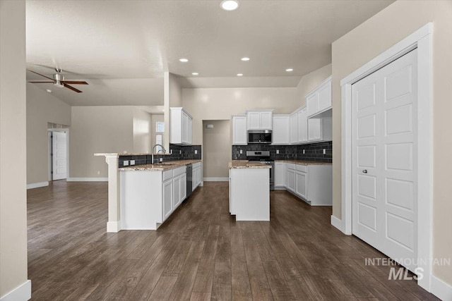 4991 N Sun Shimmer Ave, Meridian, ID 83646 - kitchen featuring appliances with stainless steel finishes, a sink, open floor plan, a peninsula, and tasteful backsplash