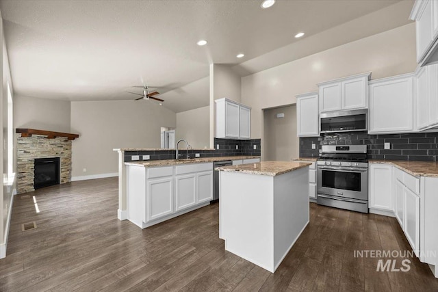 4991 N Sun Shimmer Ave, Meridian, ID 83646 - kitchen with appliances with stainless steel finishes, a peninsula, lofted ceiling, backsplash, and open floor plan