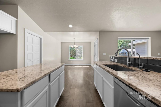 4991 N Sun Shimmer Ave, Meridian, ID 83646 - kitchen featuring a sink, stainless steel dishwasher, a chandelier, dark wood-type flooring, and light stone countertops