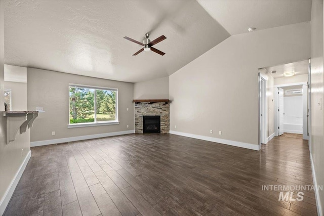 4991 N Sun Shimmer Ave, Meridian, ID 83646 - unfurnished living room featuring a ceiling fan, vaulted ceiling, dark wood-style floors, a fireplace, and baseboards