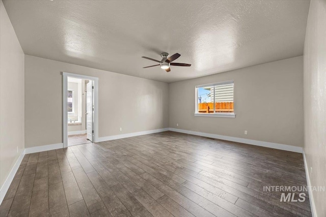 4991 N Sun Shimmer Ave, Meridian, ID 83646 - spare room with ceiling fan, dark wood-style flooring, a textured ceiling, and baseboards