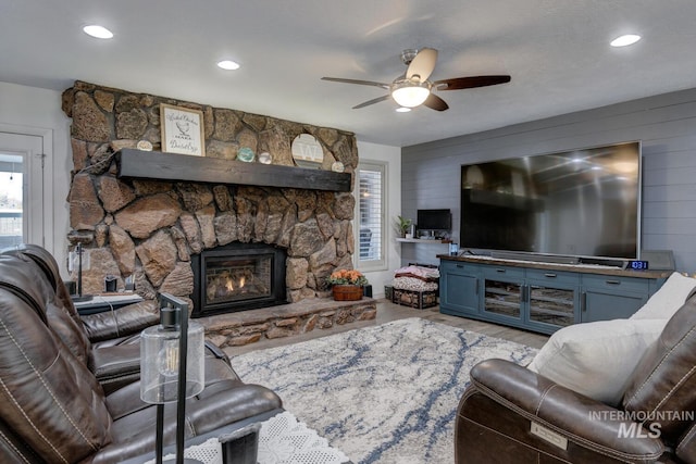 living room with ceiling fan and a fireplace