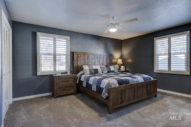 carpeted bedroom with multiple windows, ceiling fan, and a closet