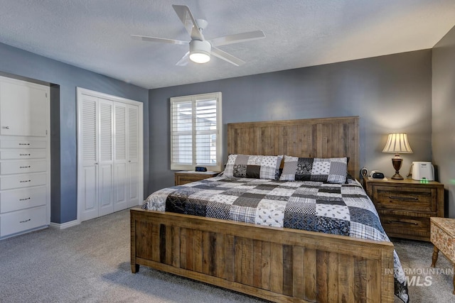 bedroom featuring light colored carpet, a textured ceiling, ceiling fan, and a closet