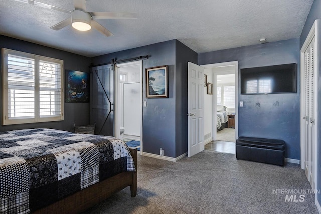 bedroom with a closet, a barn door, ceiling fan, and carpet