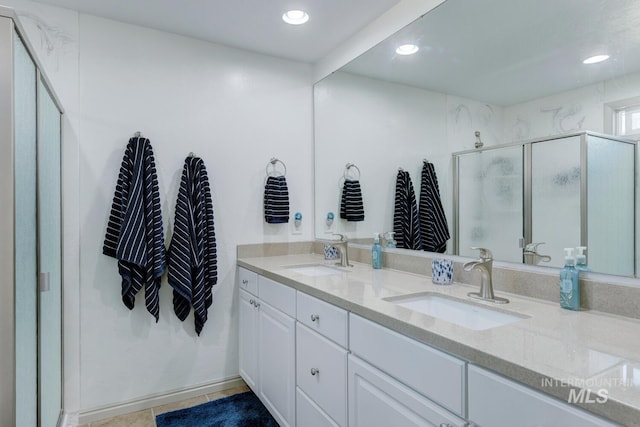 bathroom featuring a shower with door, vanity, and tile patterned floors