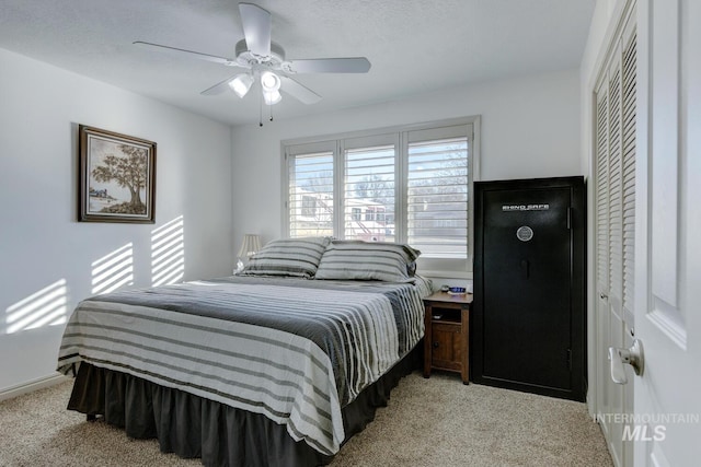 carpeted bedroom with ceiling fan and a closet