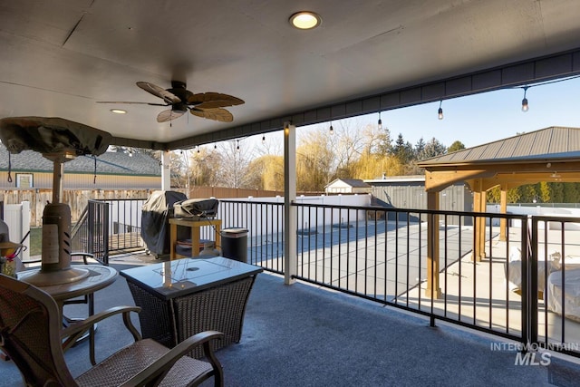 view of patio with area for grilling, ceiling fan, and a covered pool