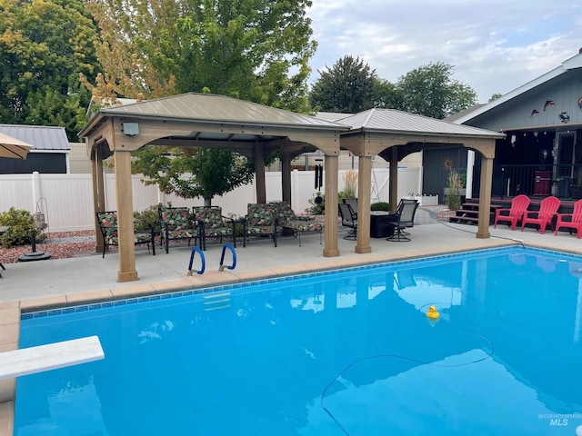 view of pool featuring a gazebo, a diving board, and a patio area