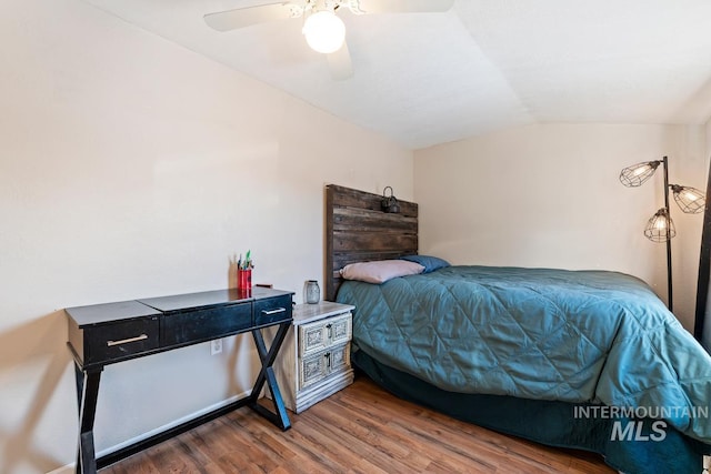 bedroom with ceiling fan, lofted ceiling, and wood-type flooring