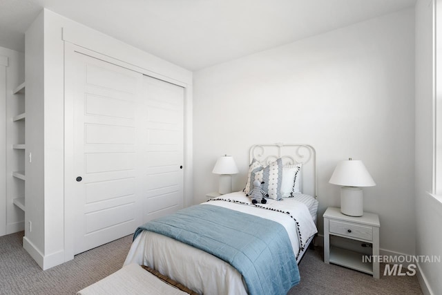 carpeted bedroom featuring a closet and baseboards