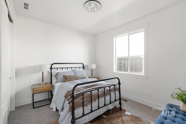 carpeted bedroom with visible vents and baseboards