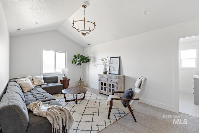 carpeted living room featuring a chandelier and lofted ceiling