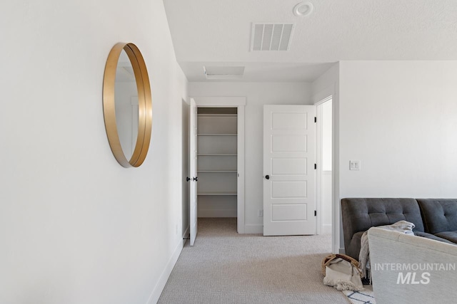 bedroom with baseboards, visible vents, a textured ceiling, and light colored carpet