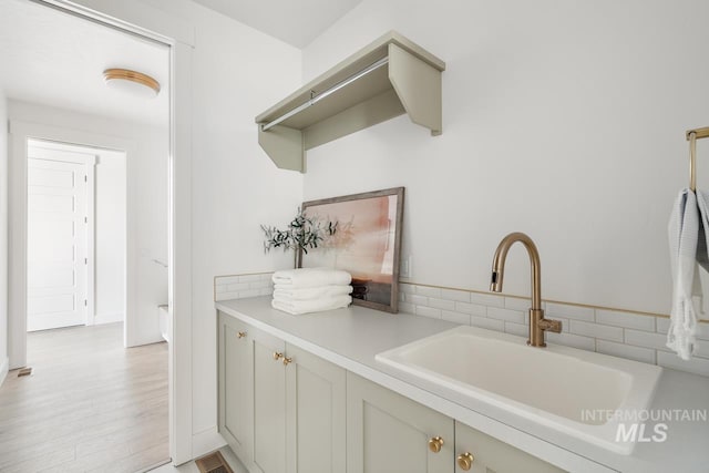 interior space with light wood finished floors, visible vents, and a sink