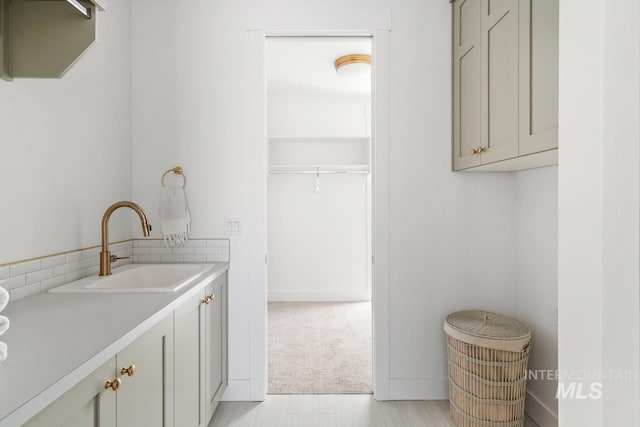 laundry room with light carpet and a sink