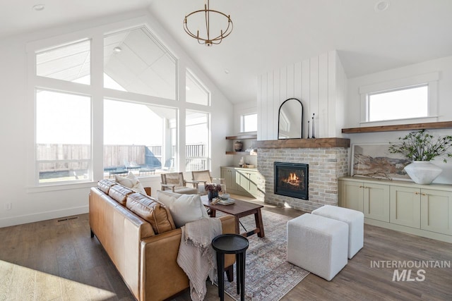 living room featuring high vaulted ceiling, dark wood-type flooring, a fireplace, and visible vents