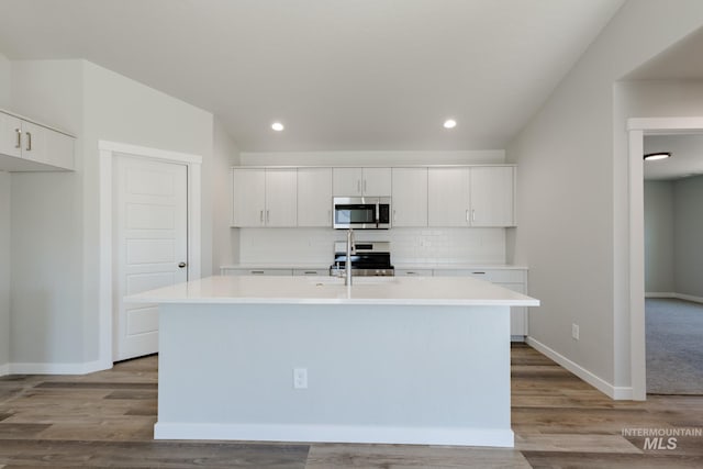 kitchen with an island with sink, white cabinetry, appliances with stainless steel finishes, and light countertops