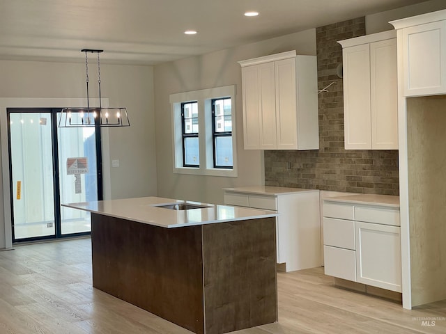 1640 E Cutgrass Ln, Eagle, ID 83616 - kitchen featuring light wood-type flooring, decorative backsplash, white cabinets, and recessed lighting