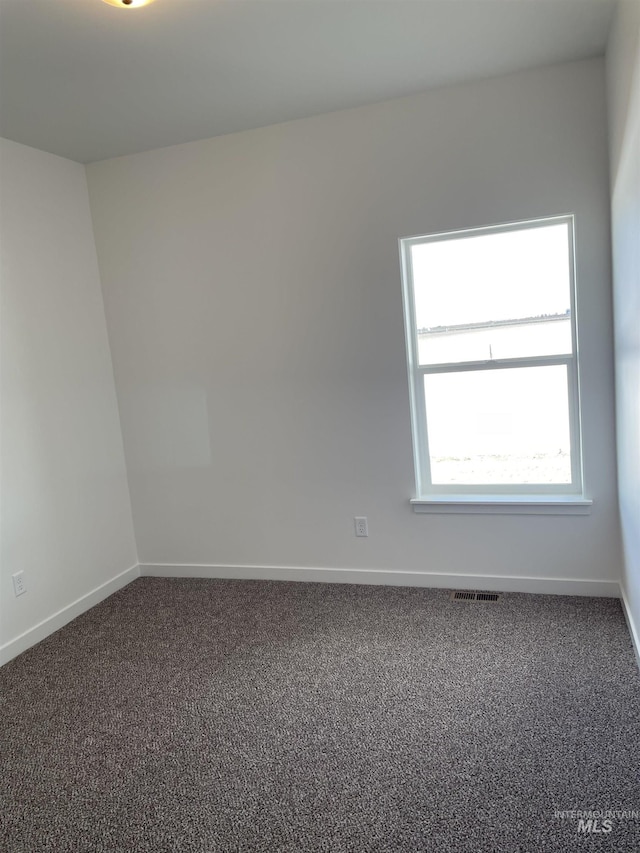 carpeted empty room with visible vents and baseboards