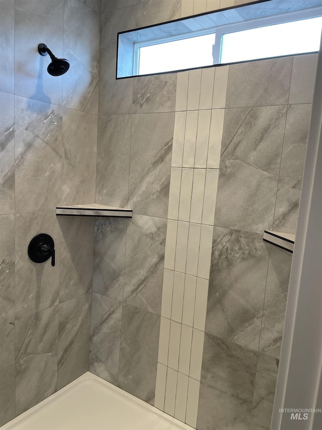 full bathroom featuring baseboard heating and a tile shower