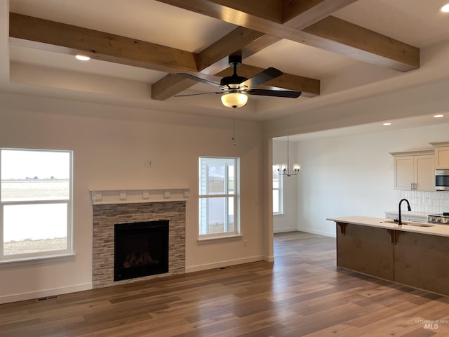 unfurnished living room with baseboards, a healthy amount of sunlight, and wood finished floors