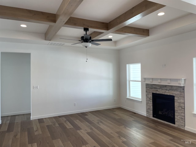 unfurnished living room with beam ceiling, baseboards, and wood finished floors