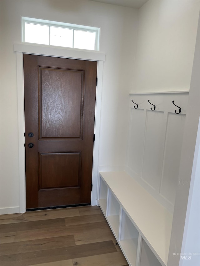 mudroom featuring light wood-style flooring and a decorative wall