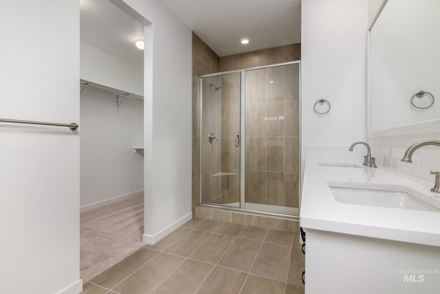 5485 N Patimos Ave, Meridian, ID 83646 - bathroom featuring tile patterned floors, a spacious closet, a shower stall, and a sink