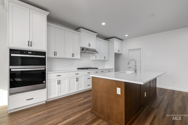 5485 N Patimos Ave, Meridian, ID 83646 - kitchen featuring stainless steel gas cooktop, under cabinet range hood, a sink, dark wood finished floors, and double wall oven