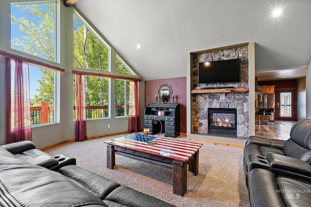 living room with high vaulted ceiling, a fireplace, and a textured ceiling