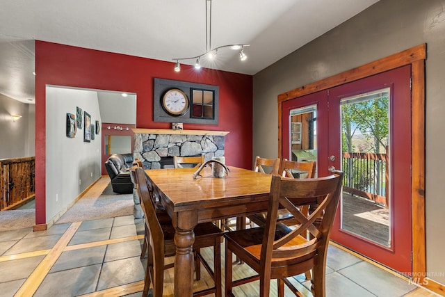 tiled dining space featuring a fireplace and french doors