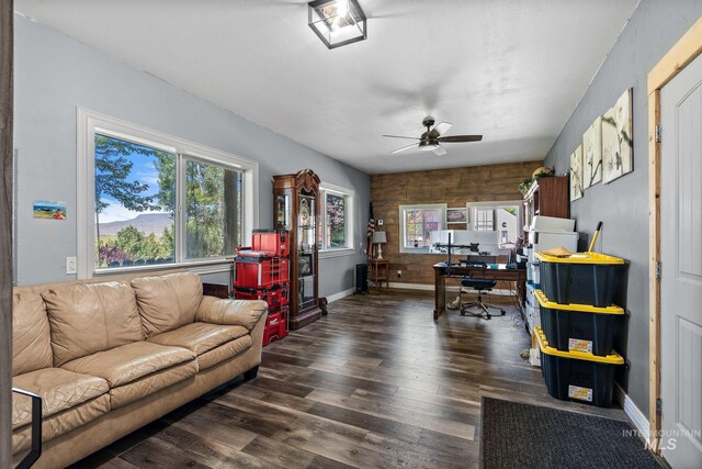 living room featuring ceiling fan and dark hardwood / wood-style floors