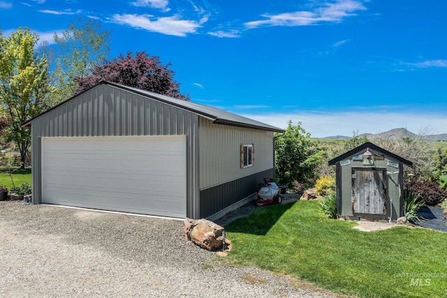 garage featuring a mountain view and a yard