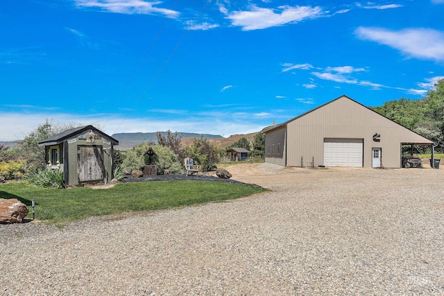 exterior space featuring a yard, an outbuilding, a garage, and a mountain view