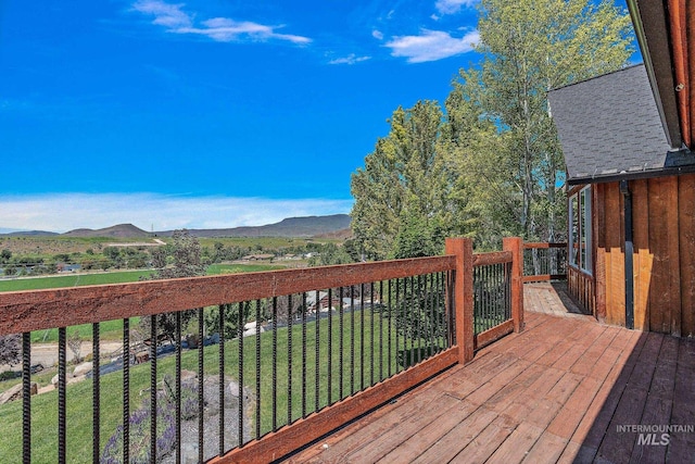 deck with a mountain view and a lawn