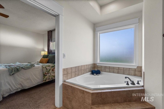 bathroom featuring a ceiling fan, a bath, and ensuite bath
