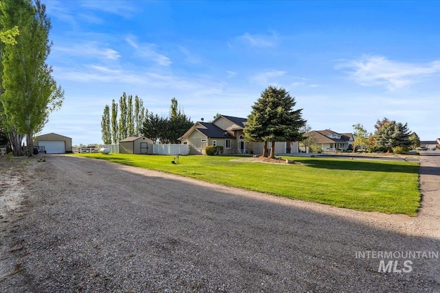 view of front of house with a front lawn, an outbuilding, a residential view, and a detached garage