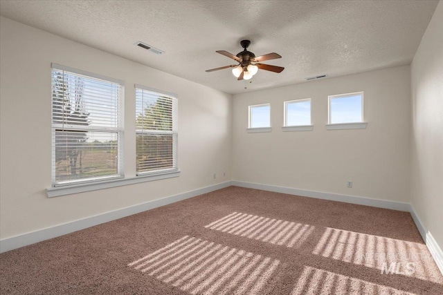 spare room featuring ceiling fan, a textured ceiling, visible vents, carpet floors, and baseboards