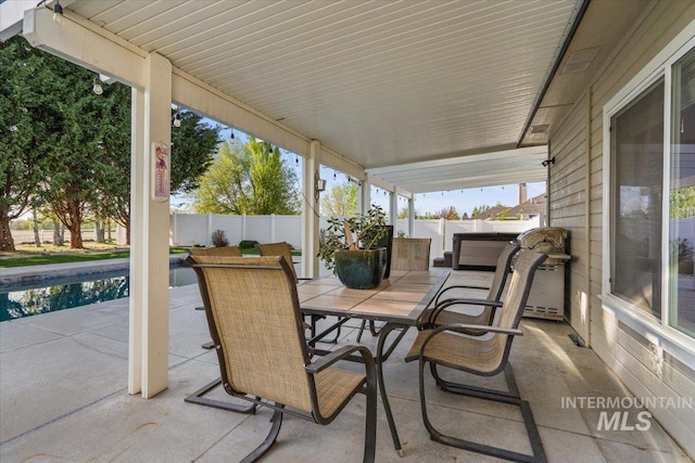 view of patio / terrace featuring outdoor dining area, a fenced backyard, a hot tub, and a fenced in pool