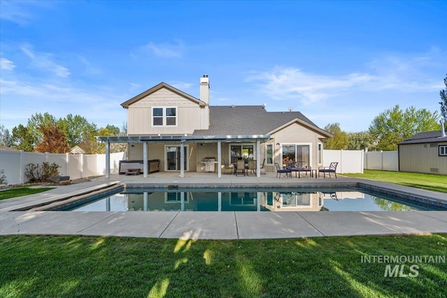 back of property with a fenced in pool, a fenced backyard, a jacuzzi, and a patio