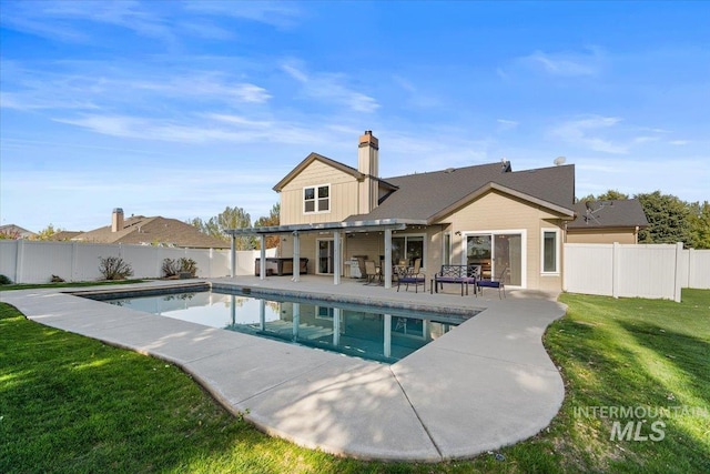 back of property with a fenced in pool, a yard, a fenced backyard, and a patio area