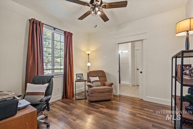 home office with baseboards, ceiling fan, and wood finished floors